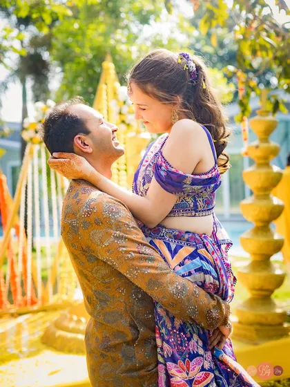 The playful romance of a Haldi ceremony. Tirath lifts Nelya, and in that moment, it's just the two of them in a world of yellow.