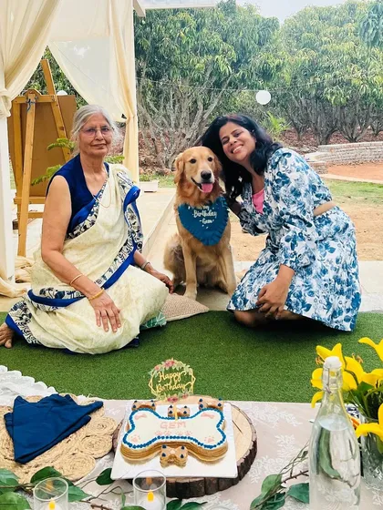 Three generations of a family celebrating their Golden Retriever's birthday with our bone-shaped cake. Dogs truly are family.