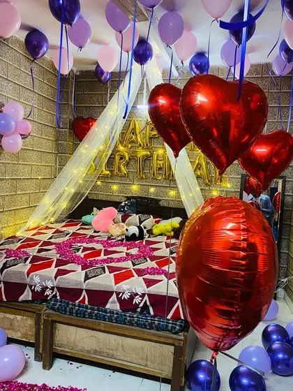 This view captures the full effect of the purple and pink balloon decor, with dozens of balloons floating on the ceiling and gathered on the floor.