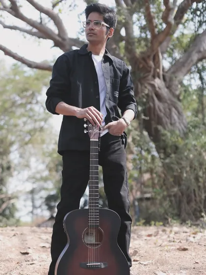 Just me and my guitar, my partner in creating music. This shot really captures how I feel when I'm in my element, ready to share stories through songs.