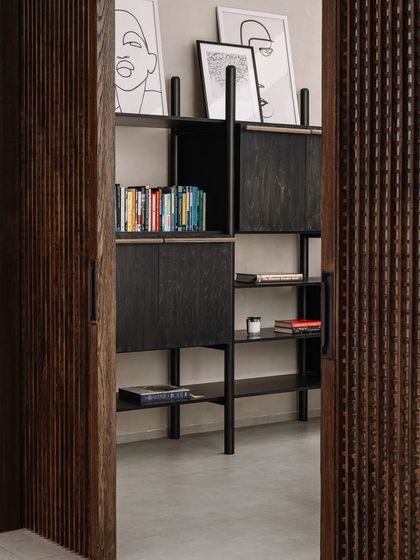 The library and study area, with its custom-designed shelving and sliding wooden doors. The space is designed to be a quiet retreat for reading and work.