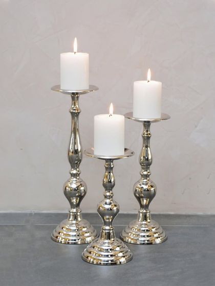 Slow down and unwind with the enchanting glow of candlelight. This set of three silver-plated candle stands adds a touch of sophistication to any room.