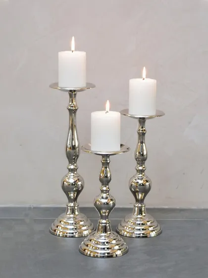 A set of three classic silver-plated candle stands. Their elegant, curved design adds a touch of sophistication and is perfect for a formal dinner or a romantic setting.