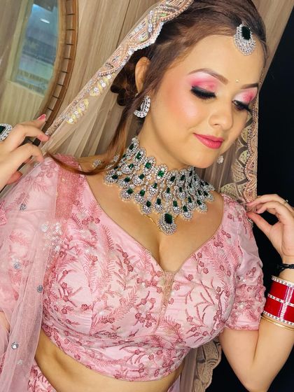 A beautiful portrait that highlights the stunning emerald jewelry and the complementary pink makeup tones.