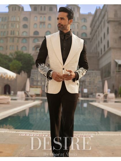 A full-length shot of the sleeveless white blazer ensemble by the pool. This look redefines formalwear with its bold, contemporary aesthetic.