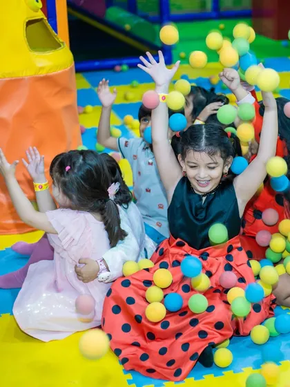 A group of girls enjoying a ball shower in the ball pit. This is a classic play activity that never gets old.