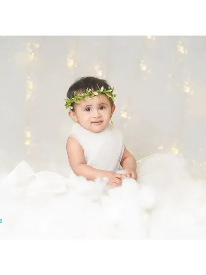 A little angel sitting amongst the clouds. Our angel theme uses soft lighting and a white backdrop to create a dreamy, ethereal feel.
