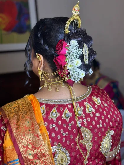 A beautiful bridal bun for a Maharashtrian ceremony, featuring an ambada hairstyle with fresh flowers and traditional hair jewelry.