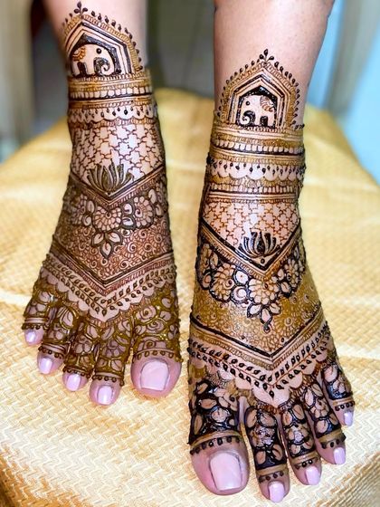 A lovely V-shaped foot design with elephant motifs at the top, surrounded by floral and net-like patterns.