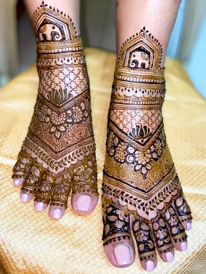 A lovely V-shaped foot design with elephant motifs at the top, surrounded by floral and net-like patterns.