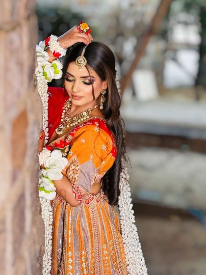 A beautiful Haldi or Mehendi look. The colorful outfit and floral jewelry are paired with bright, fresh makeup.