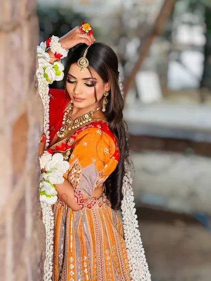 A beautiful Haldi or Mehendi look. The colorful outfit and floral jewelry are paired with bright, fresh makeup.