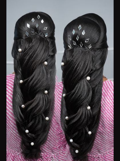 A mermaid braid on dark hair, accented with pearls and modern mirror-work accessories for a unique touch.