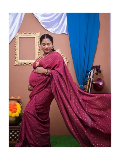 A full-length portrait showcasing the beautiful drape of a traditional saree. The pose is confident and graceful, set against a backdrop with classic elements like an ornate frame and a veena, creating a rich, cultural atmosphere.