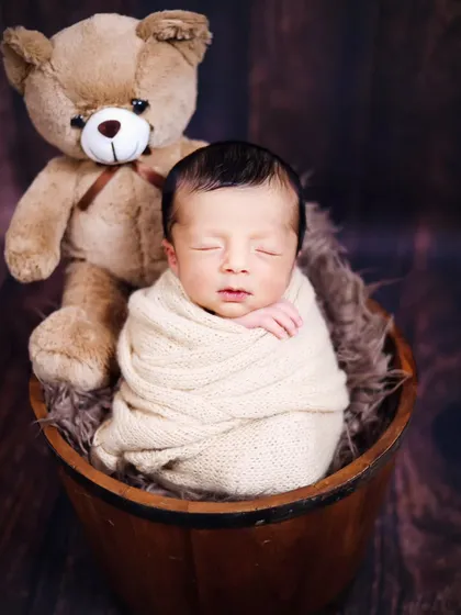 A sweet newborn portrait with a teddy bear companion. We have a variety of soft toys to include in your baby's first photoshoot.