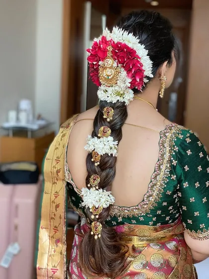 I love creating traditional South Indian bridal braids. This look features a long, thick braid beautifully decorated with fresh flowers and classic temple jewelry hair accessories for an authentic and stunning wedding day style.