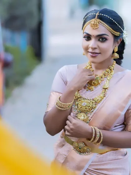 A classic muhurtham look on a model, showcasing a dewy foundation finish, soft golden eyeshadow, and deep kohl-lined eyes for a timeless appeal.