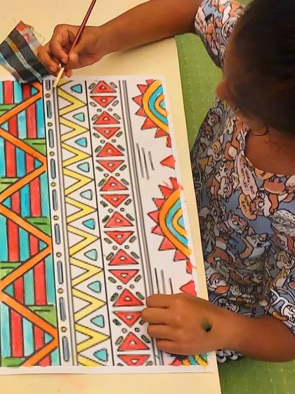 A close-up of a student's work on an African pattern design. You can see the detailed line work and the thoughtful application of color, inspired by traditional textiles.