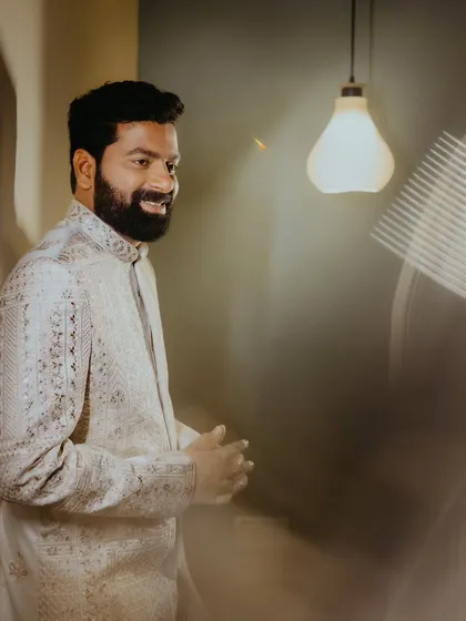 A candid portrait of the groom, smiling, with creative light trails adding a dynamic element to the shot.