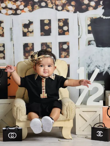 A little fashionista in the making. This creative sitter session features a "shopaholic" theme with miniature designer bags and a stylish outfit.