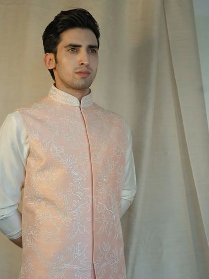 Unleash the power of floral elegance with our exquisite peach silk jacket, adorned with intricate floral dori work for a soft, romantic look.