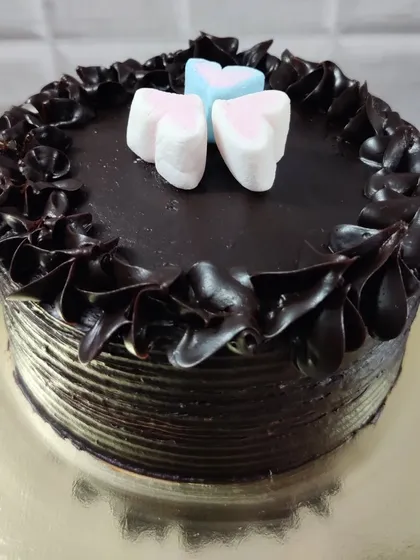 This chocolate cake is another simple design featuring heart-shaped marshmallows. The dark chocolate frosting is piped into a decorative border, making it a lovely gift for a loved one.