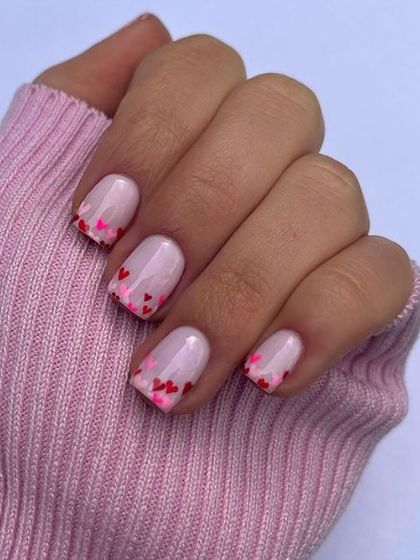 A fun twist on a French manicure, with tiny pink and red hearts creating a gradient effect at the tips. This design is playful, cute, and expertly detailed.