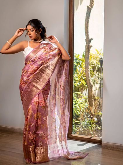 A full-length shot from the same photoshoot. The natural, glowing makeup complements the ethereal vibe of the saree and the setting.