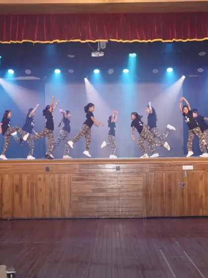 The kids' hip hop team in mid-air. This action shot captures the energy and power of their synchronized performance.