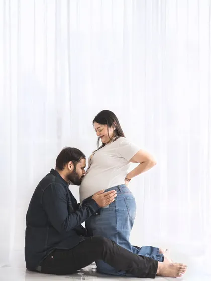 The connection between partners is a beautiful part of the pregnancy journey. We create a comfortable space for these tender, unscripted moments, like a gentle kiss to the baby bump.