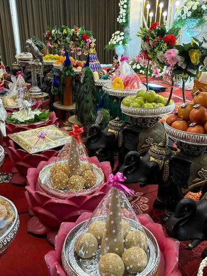 A close-up of the lotus-shaped bowls and black elephant props used for a vibrant offering table.
