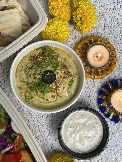 Our hummus and dip, ready to be enjoyed. The combination of creamy hummus and tangy dip is a crowd-pleaser.