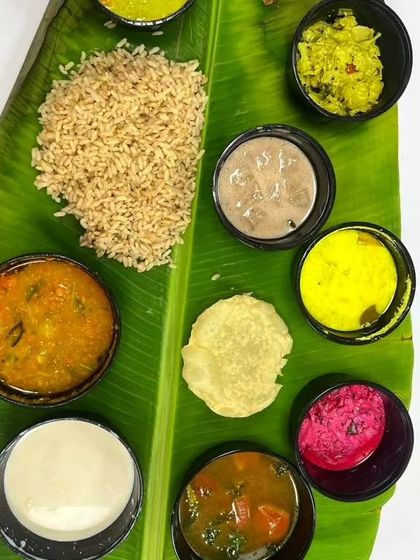 A close-up of the dishes in my Onam Sadhya meal box. This vegetarian feast includes about 15 different dishes, offering a complete and authentic taste of Kerala's harvest festival.