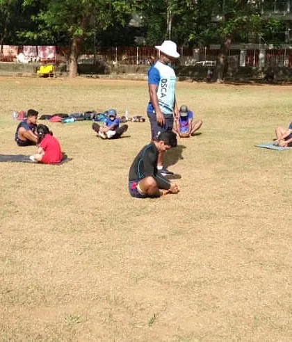Even our youngest batch participates in structured fitness sessions. Here, they are doing stretching exercises on yoga mats under a coach's supervision.