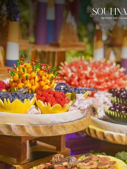 A vibrant and artistic fruit platter, featuring intricately carved melons and a colourful assortment of fresh berries and figs. Our fruit displays are a feast for the eyes at any wedding.