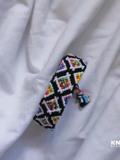 I love the way the rainbow colors pop in this diamond-patterned friendship bracelet. The black outline makes the design really stand out.