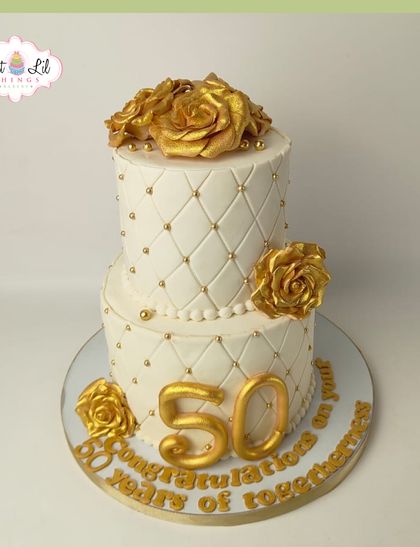 A grand and elegant cake celebrating 50 years of togetherness. This two-tiered, quilted white cake is adorned with beautiful golden roses.