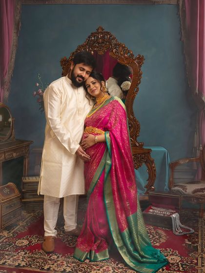 A tender moment between partners in a setting that feels like a royal chamber. The classic attire and warm lighting highlight the couple's deep connection as they await their new arrival.