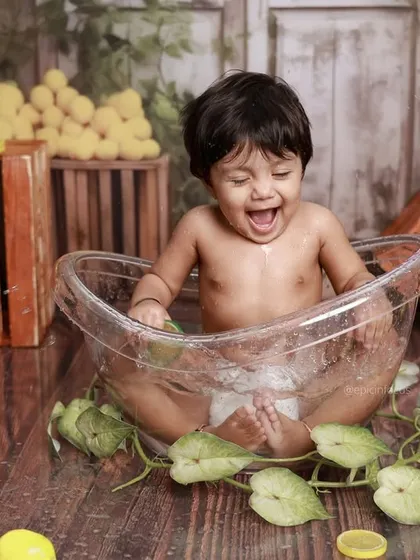 A huge, happy laugh during our unique lemon bath photoshoot. The bright yellow lemons and rustic wooden crates create a vibrant and cheerful setting.