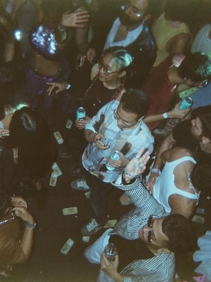 An overhead film shot of the dancefloor, littered with party props. It captures the beautiful, chaotic aftermath of a great night.