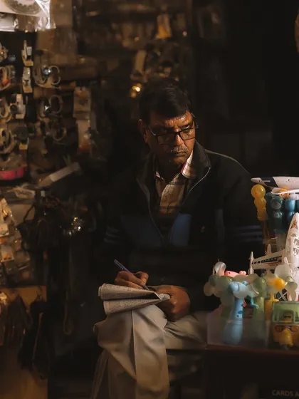 A quiet moment as a shopkeeper takes a break to do his accounts. Even in a crowded place, you can find these pockets of calm and solitude to photograph.