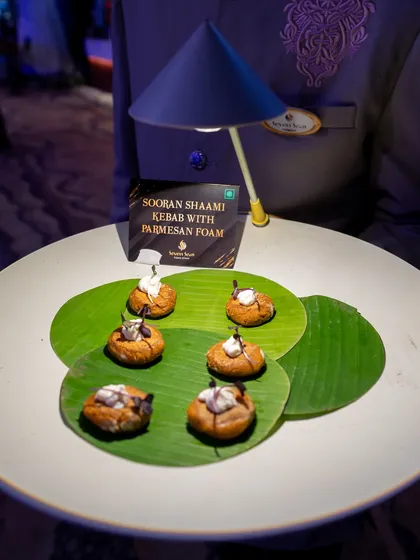 Sooran Shaami Kebab with Parmesan Foam. This appetizer combines earthy Indian flavours with a modern European technique, served on a fresh banana leaf.