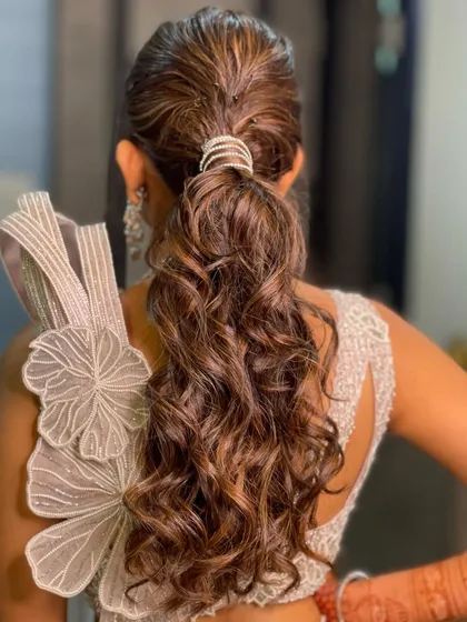 This textured high ponytail is perfect for a modern reception or cocktail party. I added soft waves for volume and finished it with a chic diamond-studded cuff to elevate the entire look.