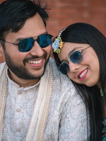 A sweet, candid moment between the couple during their Haldi. Their matching smiles and sunglasses show their fun-loving connection.