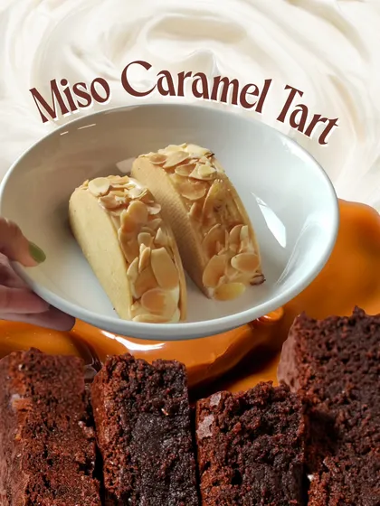 A creative shot showing the elements of our Miso Caramel Tart, with fudgy brownies and rich caramel in the background.
