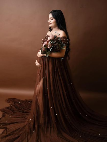 A mother's love begins before she meets her baby. This profile shot in a beautiful brown pearl-studded gown captures that sentiment perfectly.