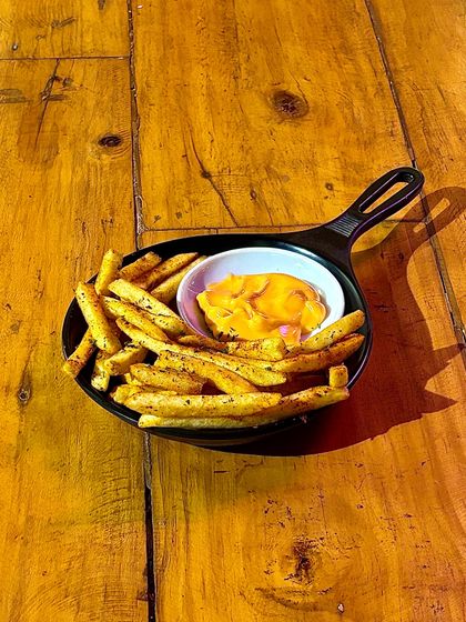 A hearty serving of our peri peri fries in a cast-iron skillet.