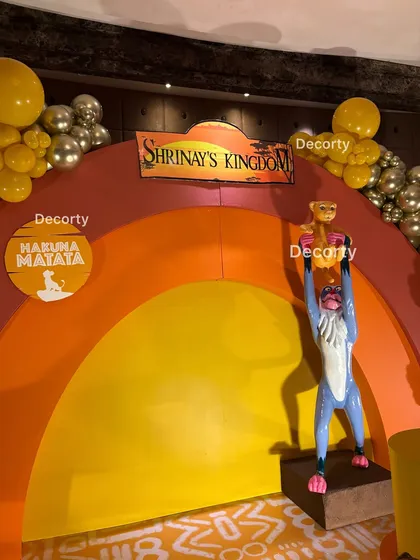 A close-up on the centerpiece of the stage: Rafiki holding Simba, with "Shrinay's Kingdom" and "Hakuna Matata" signs.