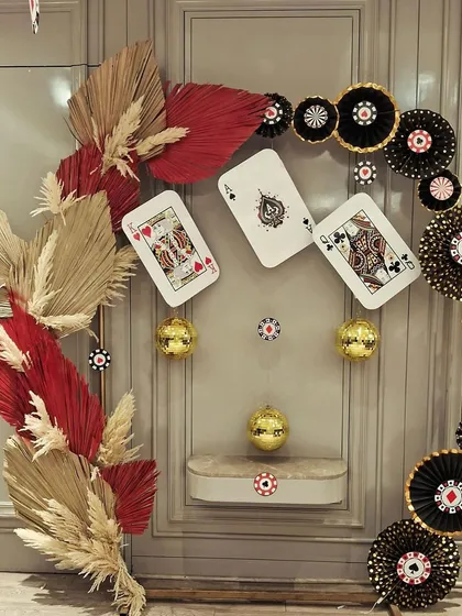 Details from a stylish Diwali card party. We used giant playing cards, poker chip fans, and dried palm leaves to create a sophisticated and thematic wall decoration.