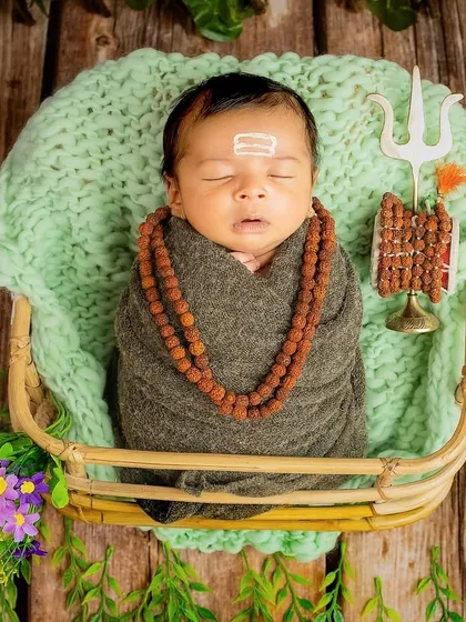 A serene little Shiv, sleeping peacefully in a basket. I use props like the rudraksha mala and Trishul to create an authentic and respectful tribute to Mahadev.